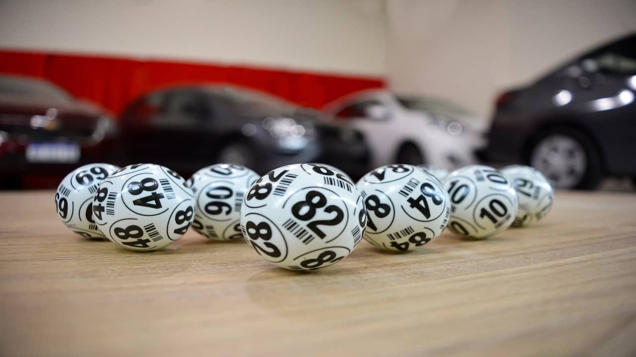 lottery balls inf front of several shiny cars