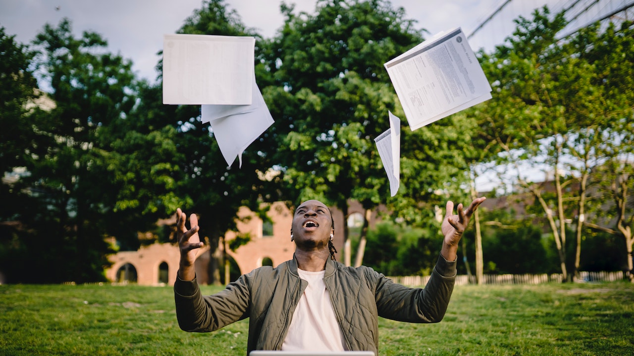 very happy man throwing papers into air