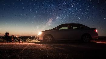 car and the person in the middle of nowhere road during night