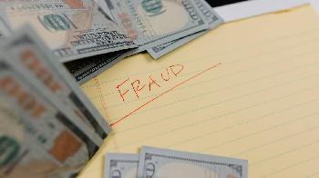 word fraud written in the notebook, banknotes lying around