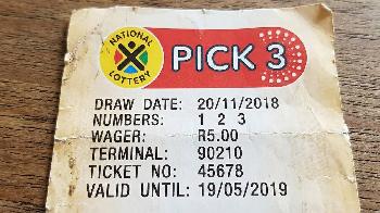 close-up of a printed South African National Lottery Pick 3 ticket resting on a wooden surface